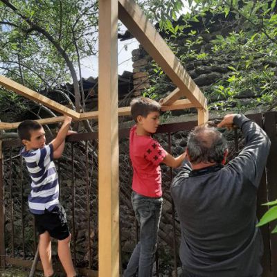 Einige Jungs helfen beim Bau eines Spielhauses